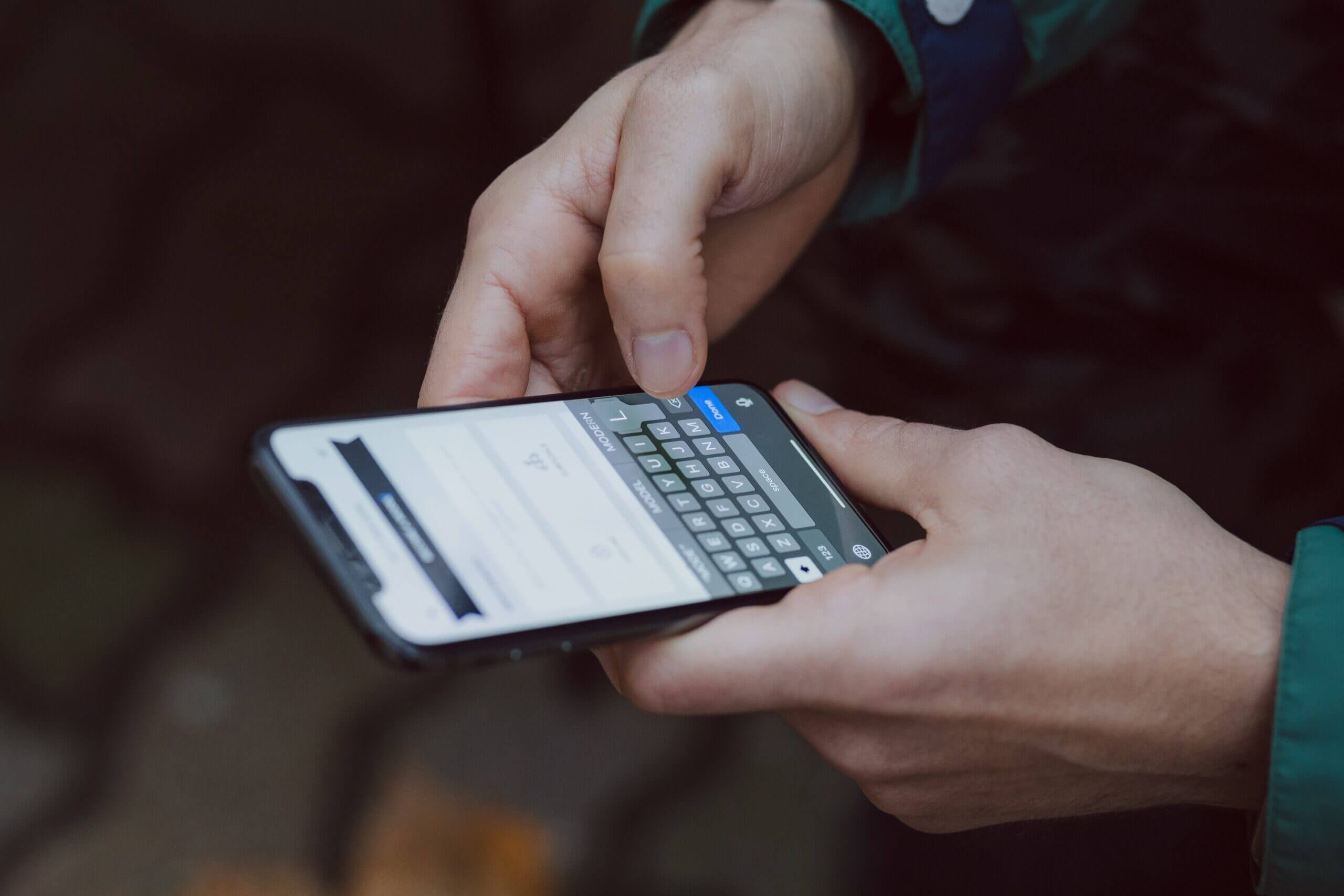 Person holding an iphone and typing with one hand