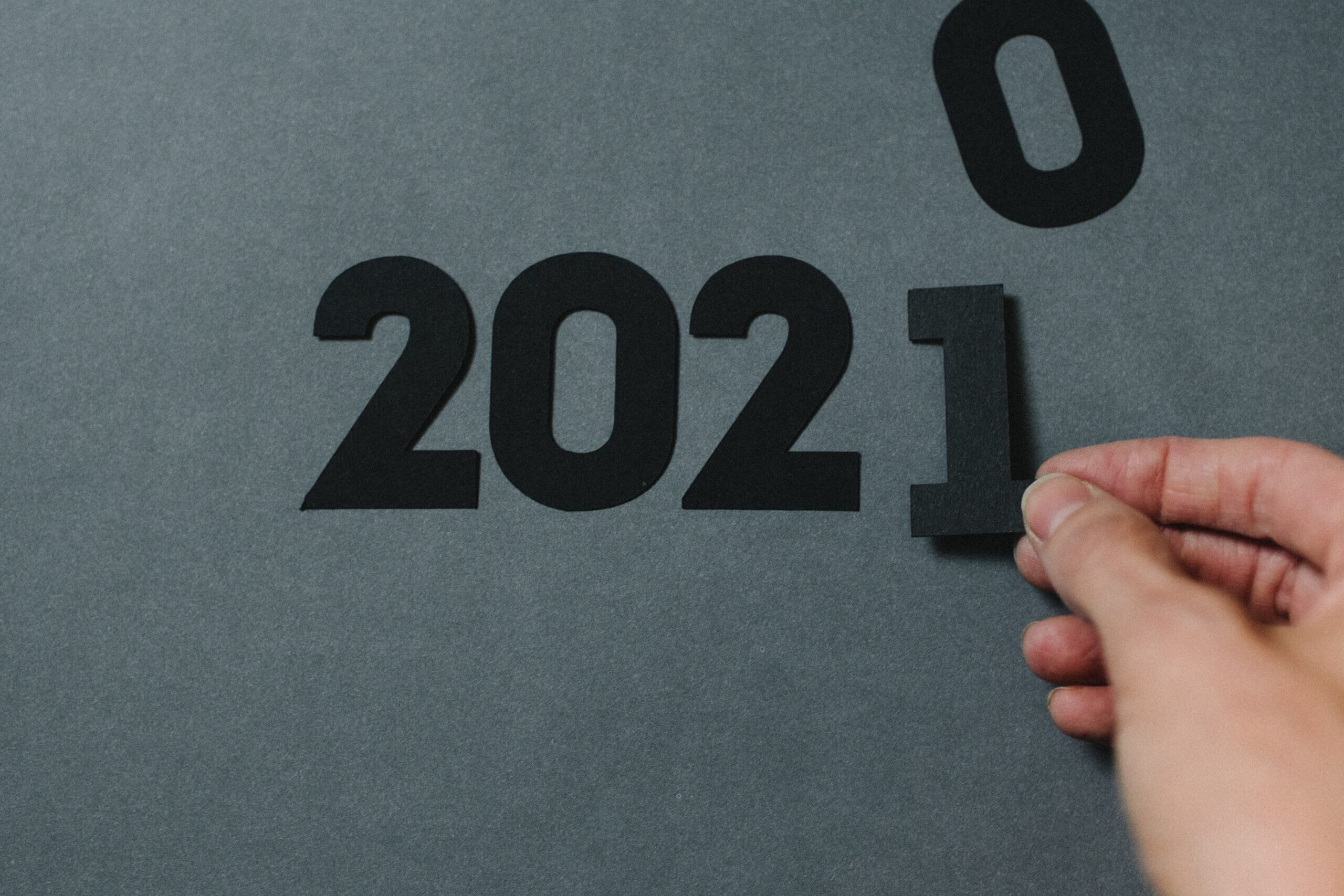Photo of someone replacing the zero of "2020" with a one.
