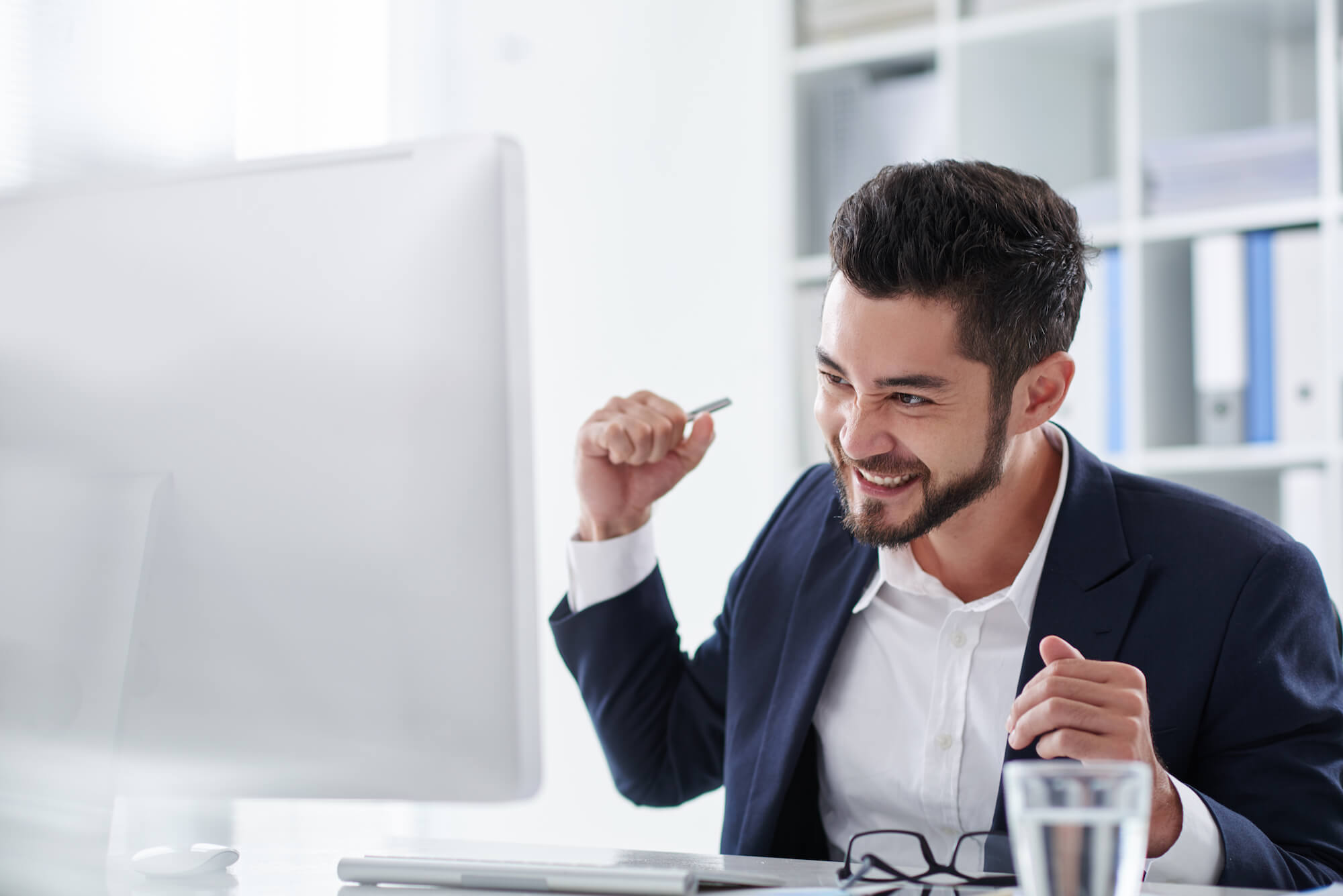 Happy man looking at computer and cheering in success