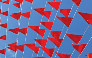 Red flag banners waving in a blue sky.