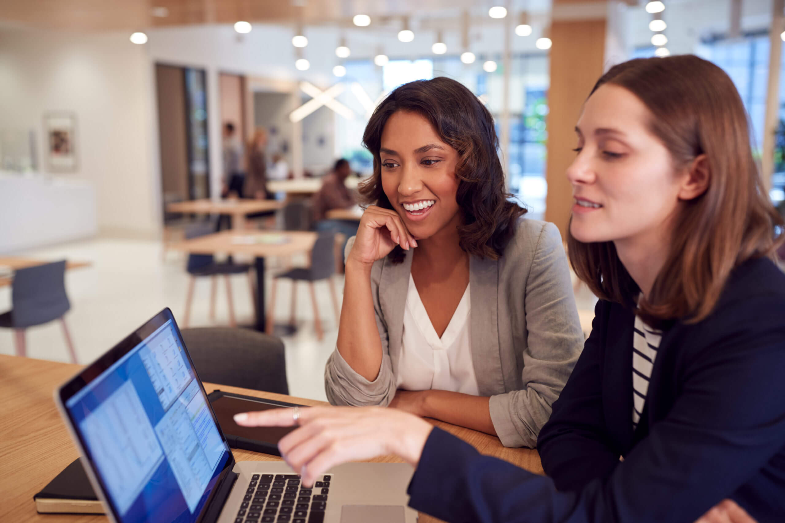 Two business women with a laptop at a desk