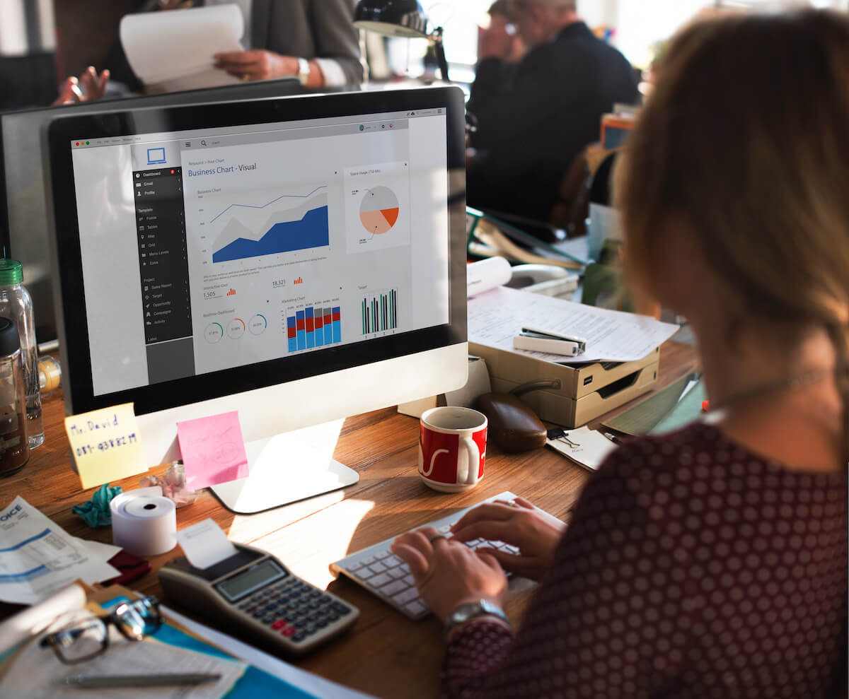 A woman analyzing Google Analytics 4 data on her computer screen.