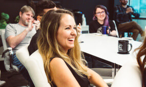 A woman laughing at a table
