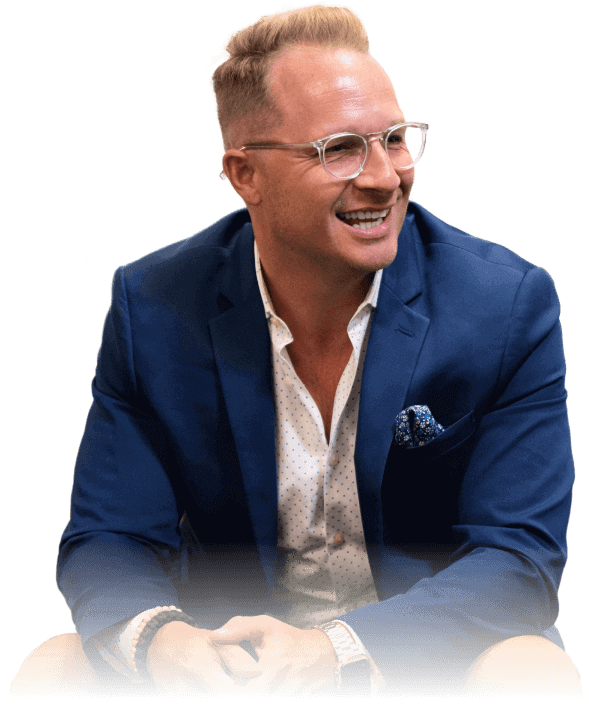 A man in a suit sitting and smiling