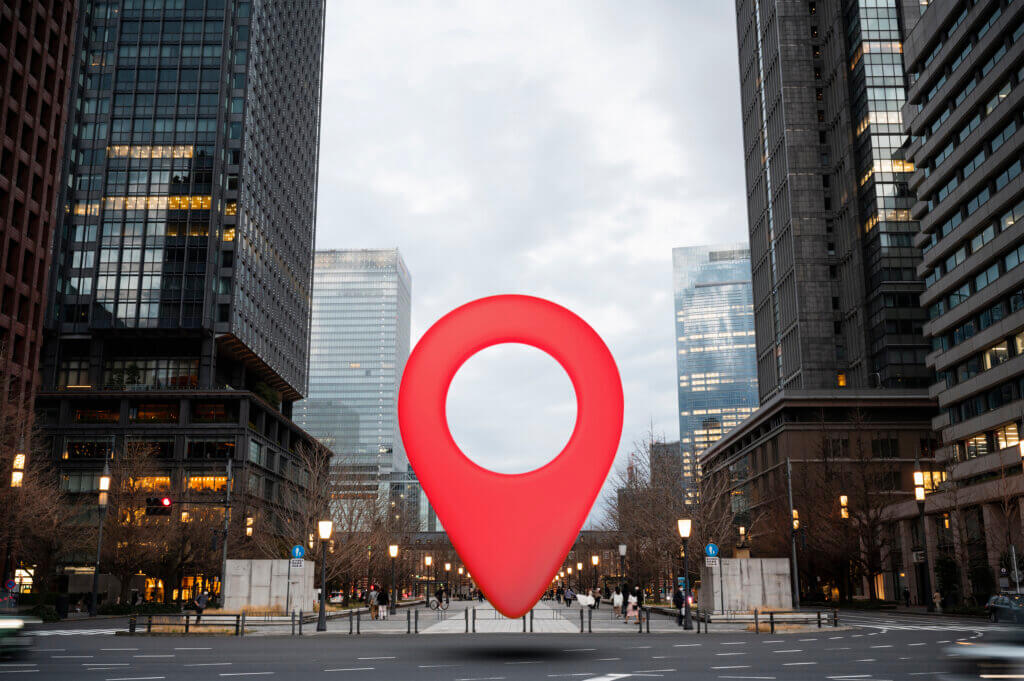 Downtown city streets with a large geo pin centered in the street.